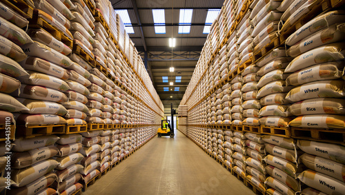 Foto Wide angle view inside a large industrial warehouse with tall shelves stacked wi