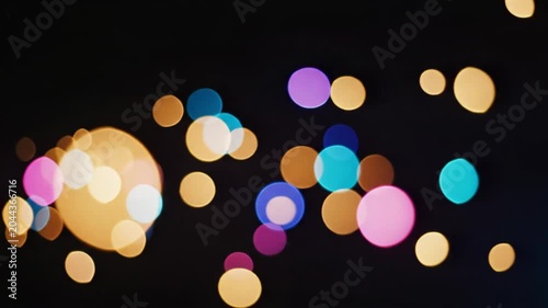 Vibrant multicolored bokeh lights scattered across a dark background with a shallow depth of field