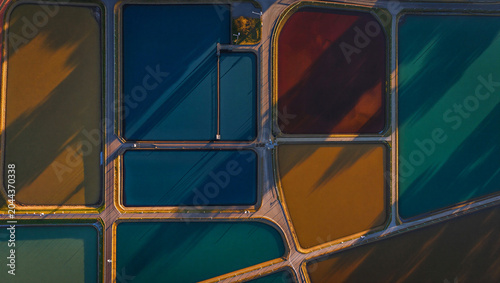 Fotografie Aerial view of colorful industrial water treatment ponds with geometric shapes a