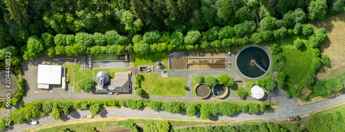 Konstfotografi Wide drone view of a rural wastewater treatment plant surrounded by agricultural fields, green landscape, pond and municipal infrastructure