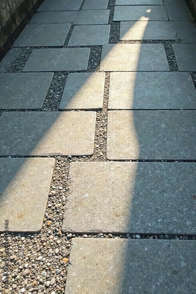 Obraz premium Sunlit Pathway A Serene Stone Walkway with Gravel Accents and Intricate Design