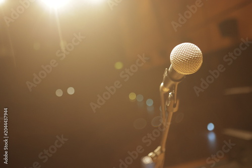 Foto Microphone waiting for singer on stage under warm light