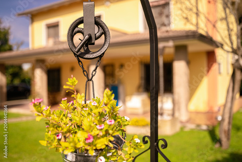 Canvastavla Decorative well pulley hanging plant in modern garden