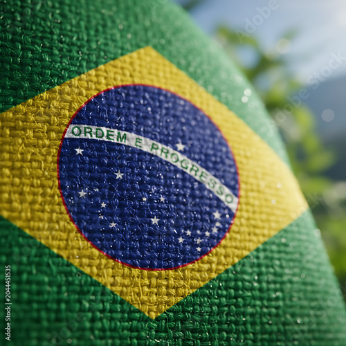 Brazilian flag detail with dew drops against lush greenery during daylight