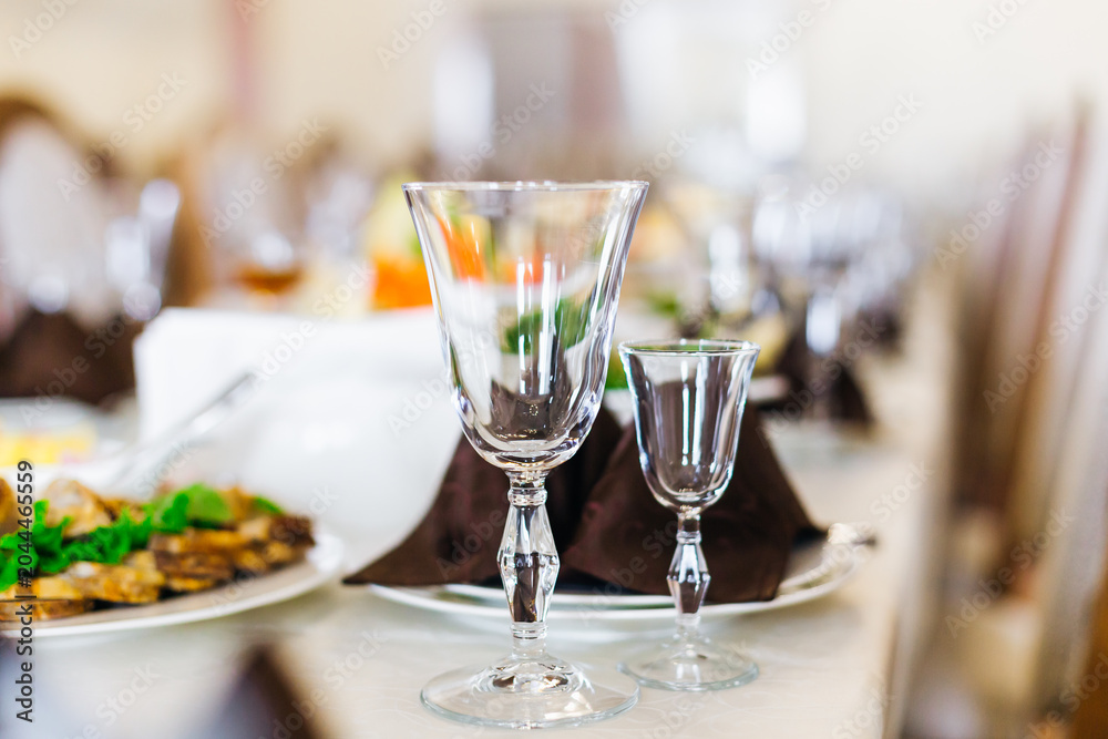 Fototapeta premium Formal wedding banquet table with crystal wine glasses and elegant place settings