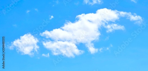 Fotografie A bright blue sky with a few white clouds scattered across it, captured in a wide-angle shot with a clear and serene atmosphere