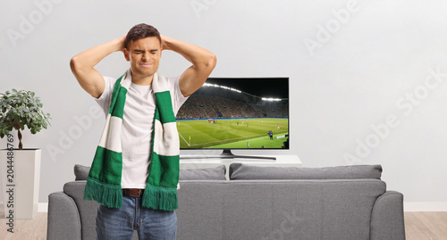 Disappointed man standing in front of a tv