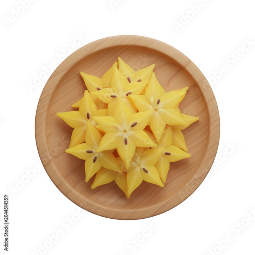 A top-down view of starfruit sliced ​​into star shapes arranged on a round wooden tray, isolated on a transparent background