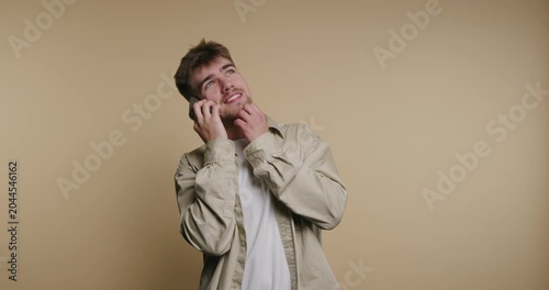 Man talks on phone, smiles, and shows different expressions in studio setting indoors