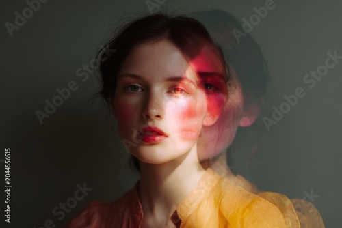 Double exposure portrait of woman with red light and ghosted profile for editorial background and poster design