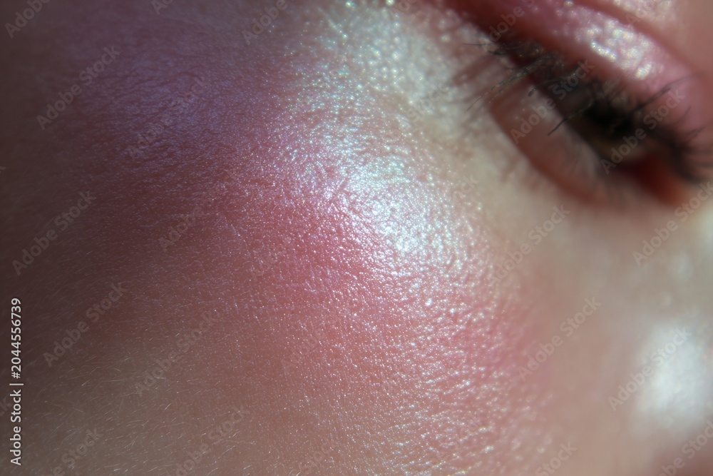 Fototapeta premium Closeup iridescent cheek highlight on natural skin for beauty marketing background and makeup banner use