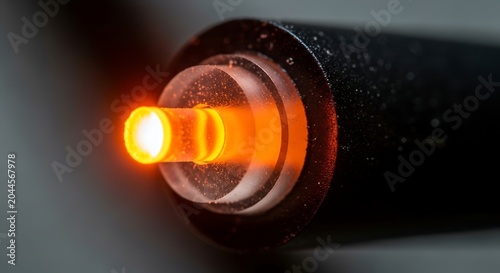 Close-up of glowing orange fiber optic cable connector with high speed, internet