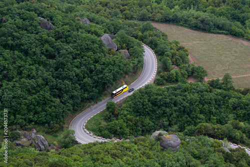 Foto Winding road through green forest in Meteora Greece