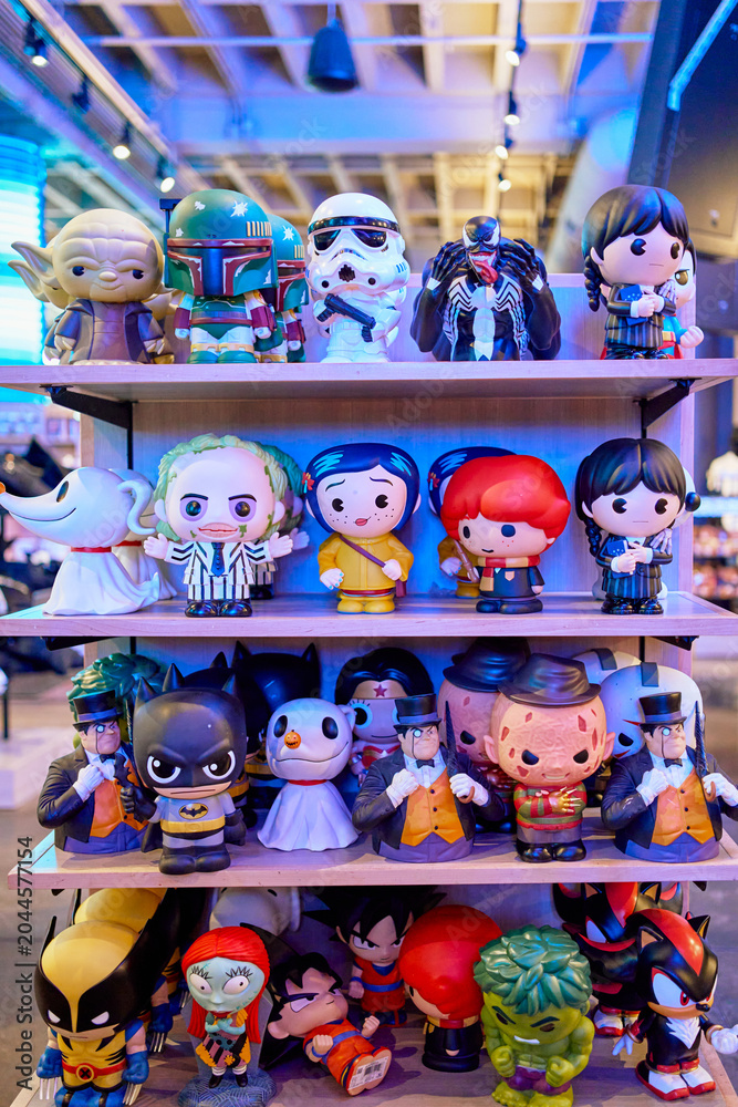 Naklejka premium Collection of various pop culture character vinyl figures and bobbleheads displayed on shelves in a store