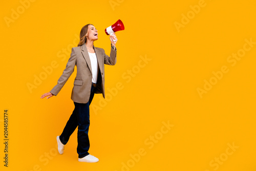 Schilderij op canvas Young woman in blazer holding a red megaphone making an energetic announcement o