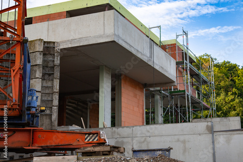 a professional construction site with a large crane and concrete elements of a new house under development