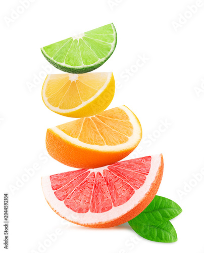 Fresh orange, lemon, lime, grapefruit slice slices on top of each other with green leaf