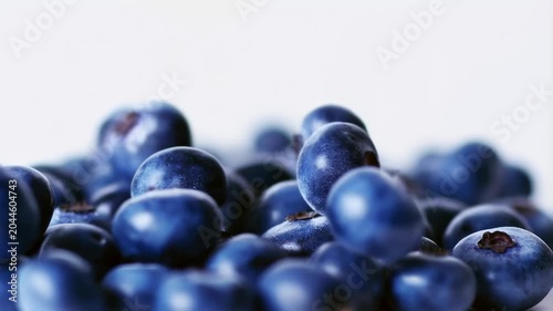 Fresh blueberries falling onto a pile, showcasing their vibrant color and texture. Ideal for healthy eating, cooking, and smoothie preparation