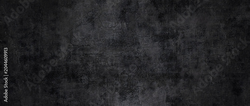 Fotografie Grunge texture background on a dark black cracked concrete wall with moody distr