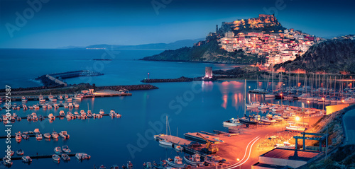 Сharm of the ancient cities of Europe. Panoramic night cityscape of Castelsardo port. Illuminated outdoor scene of Sardinia island, Province of Sassari, Italy, Europe. Aerial Mediterranean seascape.
