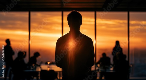 Silhouetted figure stands before a city vista bathed in warm sunset light