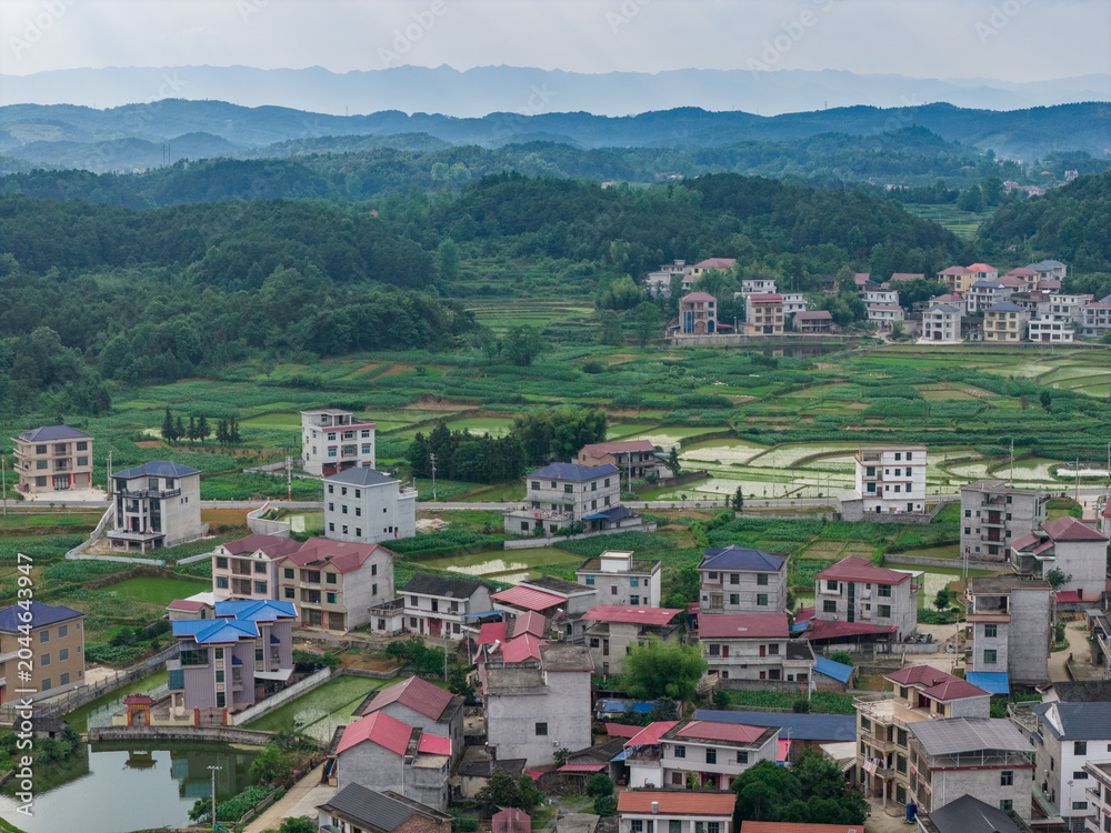 Fototapeta premium Aerial view of rural houses and green pastoral scenery