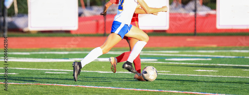 Players Chase the Soccer Ball During a Game on the Field