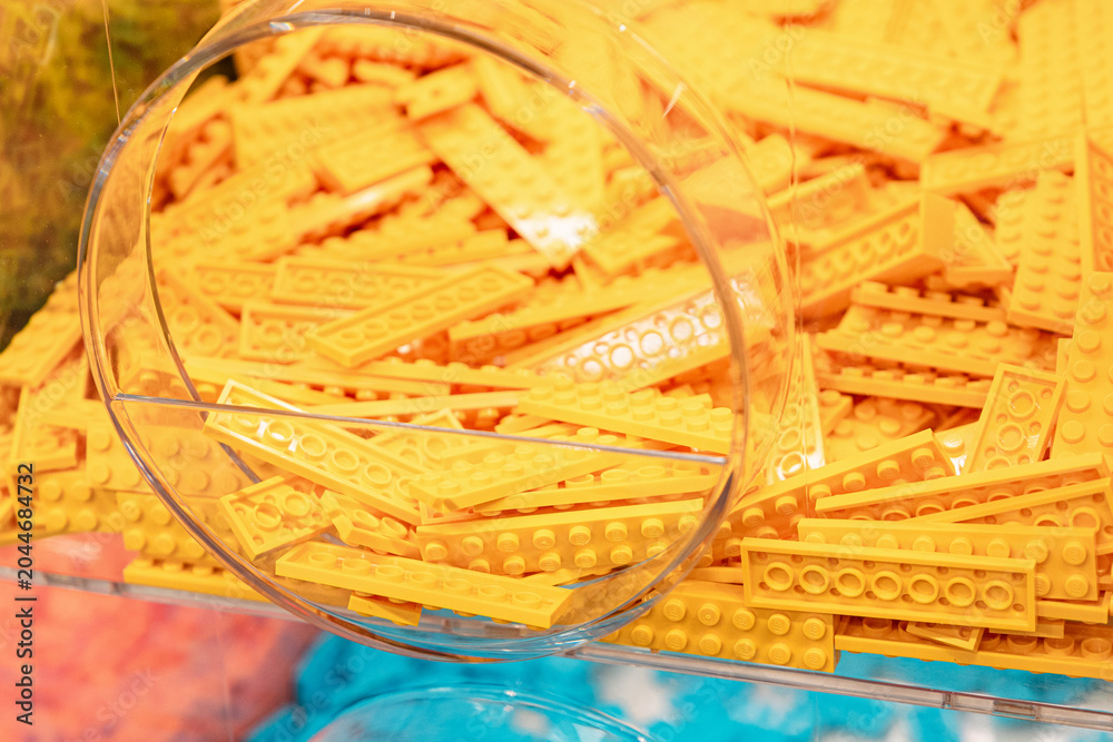 Obraz premium 19 October 2025, Belgrade, Serbia: Yellow LEGO plastic toy bricks filling a clear display bin at a retail store, offering elements for building and construction hobby