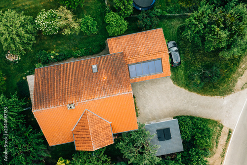 Close aerial view of single farmhouse with red tile roof and courtyard
