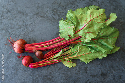Chard with beetroots. Young beetroot with fresh leaves on dark background