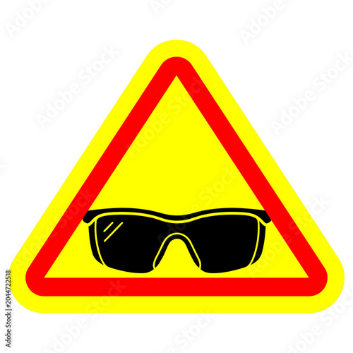 Yellow Triangular Warning Sign with Black Safety Glasses Icon and Red Border.