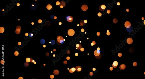 Golden bokeh lights scatter across a dark background. The lights create a dreamy, abstract pattern with varying sizes and colors, primarily shades of orange and yellow.