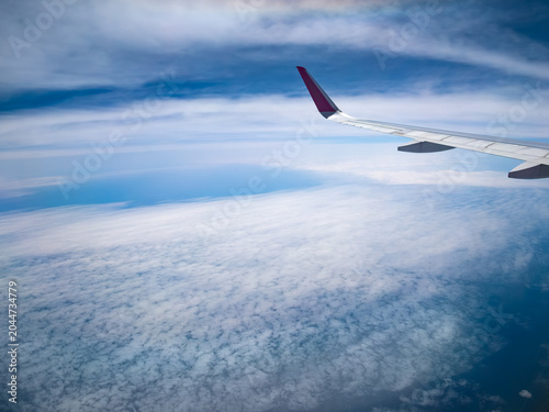 飛行機の窓から見下ろす雲海と青空