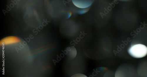 Abstract cinematic lens flare with soft bokeh circles and subtle light reflections. Atmospheric optical effect background ideal for overlays, visual effects, film production and creative design.