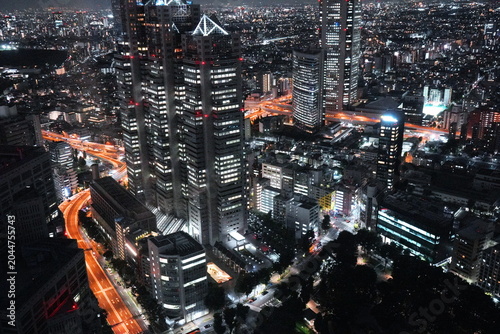 Tableau sur toile 西新宿の摩天楼が夜空に輝く東京都心の壮大な夜景。ライトアップされた東京都庁舎や周辺の高層ビル群が密度高く並び道路を行き交う車の光が美しい光跡を描いている。