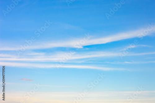 A serene, wide-angle shot of a clear blue sky layered with soft, thin, streaks of wispy white cirrus clouds.