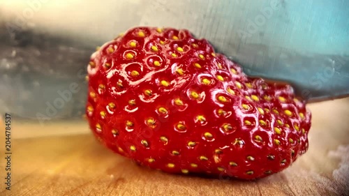 Cutting fresh strawberry macro close up knife slicing ripe berry juicy fruit food preparation concept