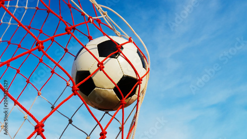 Valokuva Soccer ball hitting the red and white net scoring a goal during football match w