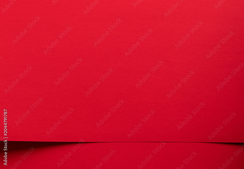 Fototapeta premium Red paper background with a subtle horizontal fold. Minimal textured surface for design, branding, and copy space. Clean abstract backdrop for templates and packaging..