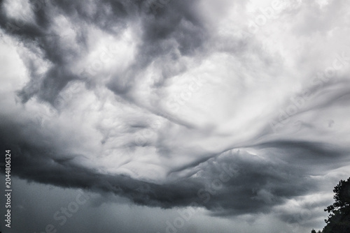 Foto Dramatic Swirling Storm Clouds Forming Across A Darkened Atmospheric Sky