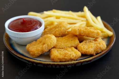 Tableau sur toile Homemade Chicken Nuggets and French Fries with Ketchup on a Plate, side view
