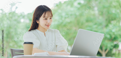 Φωτογραφία テラスでパソコンを使う若い女性