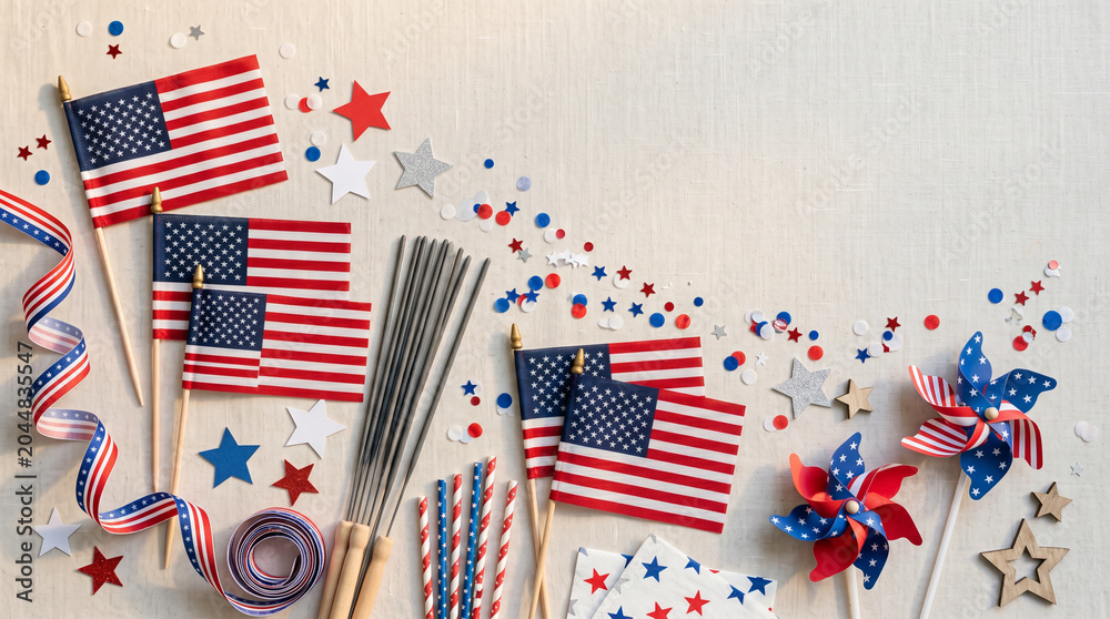 Obraz premium Top view of patriotic Fourth of July decorations including American flags pinwheels sparklers and stars on a neutral linen background with copy space for text.