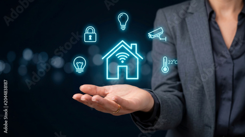 Businesswoman holding a glowing smart home hologram with security, climate, and lighting icons. Home automation and internet of things concept