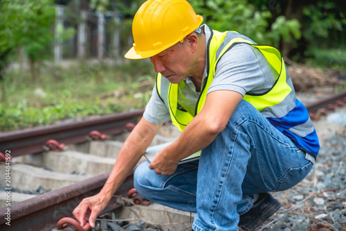 Foto Senior Japanese train engineer working outdoor at rail tracks inspecting railway