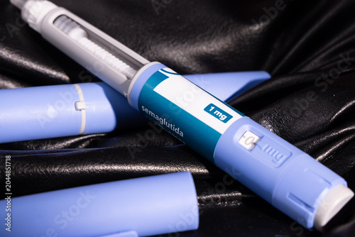 Semaglutide glp1 weight loss injection devices displayed on dark black leather pants for type 2 diabetes control and lifestyle.