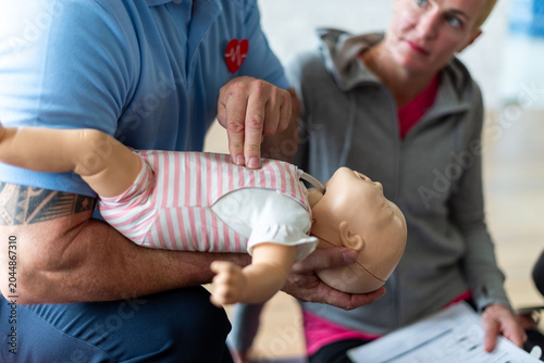 Foto Person demonstrating CPR on a baby mannequin during a training session