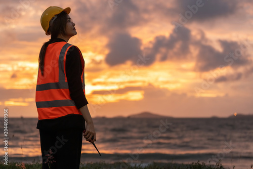 Foto Asian female engineer coordinating offshore projects near a drilling rig, strengthening Industry competitiveness through AI technology, safety management, and planning