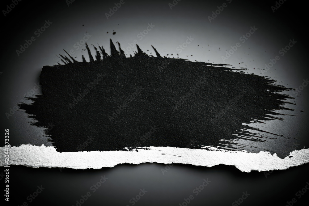 Fototapeta premium Creative artwork of torn paper with black paint on a dark background