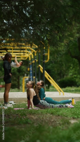 Three young women practice yoga and fitness outdoors in a lush green park. They are engaging in a healthy and active lifestyle on a beautiful day